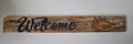 Handcrafted rustic timber welcome sign with laser engraved script lettering and cabin pine trees motif
